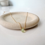 Pale green prehnite teardrop necklace in 14k gold-filled on a stoneware dish