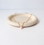 Pink opal teardrop necklace on a speckled ceramic dish