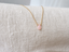 Minimal pink opal teardrop necklace on natural linen