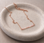 Rose gold filled pink opal beaded bar necklace on a speckled ceramic dish