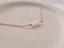 Rose gold-filled opal necklace on a ceramic dish