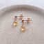 Rose gold filled citrine drop stud earrings on a ceramic dish