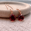 Rose gold-filled garnet threader earrings with faceted garnet drops on a stone dish