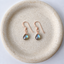 Rose gold-filled labradorite drop earrings on a speckled stoneware dish