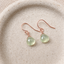 Prehnite heart drop earrings in 14k rose gold-filled on a speckled ceramic dish