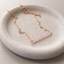 Rose quartz beaded bar necklace in rose gold filled with faceted pink rose quartz rondelles on a fine cable chain, in a stone dish