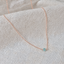 Rose gold-filled faceted aquamarine bead necklace on textured white linen