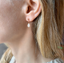 Rose gold opal teardrop stud earring worn on the ear