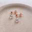 Rose gold-filled cubic zirconia teardrop stud earrings on a ceramic dish