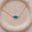 Turquoise three-bead necklace in 14k rose gold-filled with three faceted turquoise rondelles on a dainty cable chain, on a speckled stoneware dish