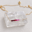 Gold-filled ombré ruby beaded bar necklace with spring ring clasp displayed on a clear crystal