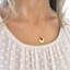 Ruby initial necklace worn with a textured ivory blouse