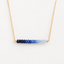 Gold-filled ombré sapphire bar necklace showing the gradient from dark blue to pale blue sapphire
