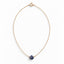A faceted sapphire gemstone hangs from a delicate gold filled cable chain necklace 