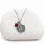Sterling silver initial disc necklace stamped with A and genuine ruby teardrop and rondelle charms on a white stone