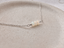 Sterling silver opal necklace on a speckled ceramic dish