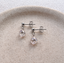 Sterling silver cubic zirconia teardrop stud earrings on a ceramic dish