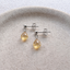 Sterling silver citrine drop stud earrings on a ceramic dish