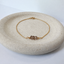 Dainty smoky quartz bracelet in 14k gold-filled on a stone dish