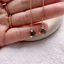 Pair of faceted smoky quartz threader earrings held in hand