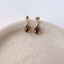 Smoky quartz teardrop stud earrings in 14k gold-filled on a ceramic dish