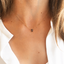 Smoky quartz teardrop necklace worn with a white collared shirt