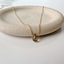 Smoky quartz teardrop necklace in 14k gold-filled on a stone dish
