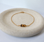 Dainty tiger's eye bracelet in 14k gold-filled on a stone dish