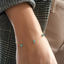 Model wearing a dainty turquoise station bracelet in 14k gold-filled on the wrist