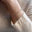 Model wearing a 14k gold-filled turquoise station bracelet with an ivory knit sweater