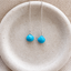 Turquoise threader earrings in sterling silver with faceted heart-shaped turquoise briolettes on fine cable chains, in a speckled ceramic dish