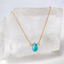 Turquoise teardrop necklace on a gold filled cable chain resting on a crystal slab - Lolabean