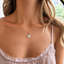 Dainty turquoise initial necklace on a fine gold filled chain, worn with a mauve lace camisole