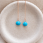 Turquoise threader earrings in rose gold filled with faceted heart-shaped turquoise briolettes on fine cable chains, in a speckled ceramic dish