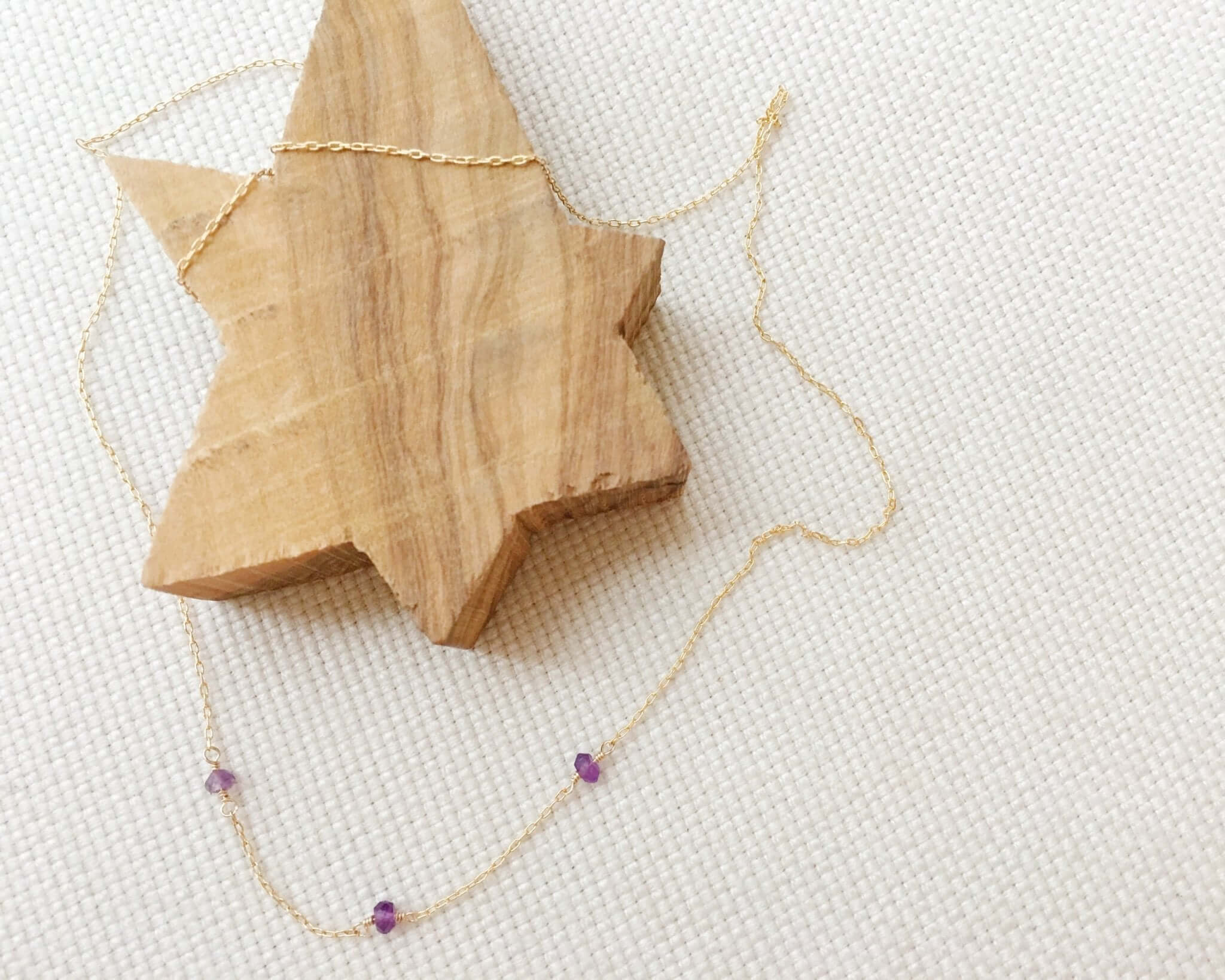 Amethyst Station Necklace with three evenly spaced amethyst stones on a delicate gold chain