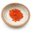 Loose faceted carnelian teardrop gemstones in a bowl