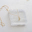 a tiny crescent moon charm is displayed on a dainty gold filled cable chain