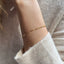 A dainty gold dapped chain bracelet displayed on a model