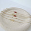 Dainty gold filled birthstone beaded bracelets on stone dish
