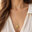 Greek Pegasus pendant necklace styled on model in ivory blouse