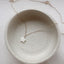 Dainty 14k gold filled mother of pearl star charm necklace on ceramic dish