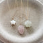 Nature inspired charm necklace collection with mother of pearl star rose quartz feather and prehnite blossom on ceramic dish