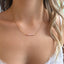 Dainty pink opal bar necklace worn at the collarbone with a pink camisole