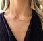 Pink opal bead bar necklace against a burgundy sweater