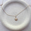 Close up of dainty 14k gold filled starfish charm necklace on ceramic dish