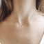 model is showing wearing a tiny crescent moon charm